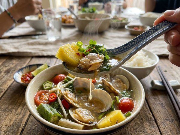 Thìa canh múc thịt ngao béo ngậy kèm dứa ngọt và rau thơm thì là